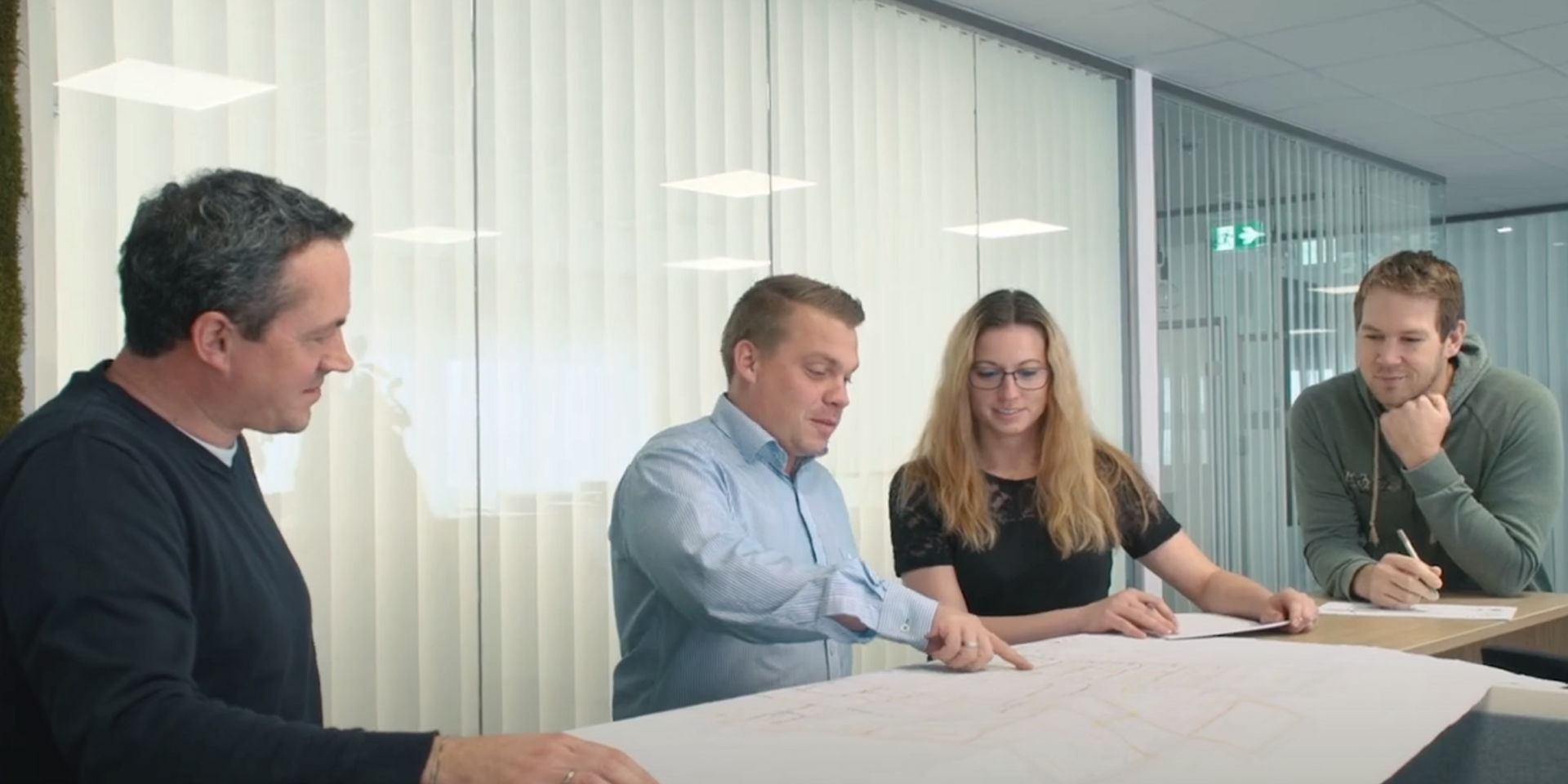PMS Mitarbeiter:innen in der Runde mit Peter Jörg beim Besprechen einer Unterlage am Besprechungstisch