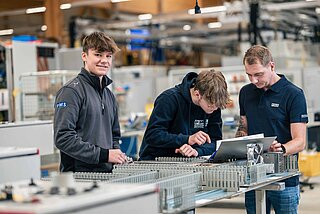 3 Lehrlinge beim Arbeiten in der Fertigung